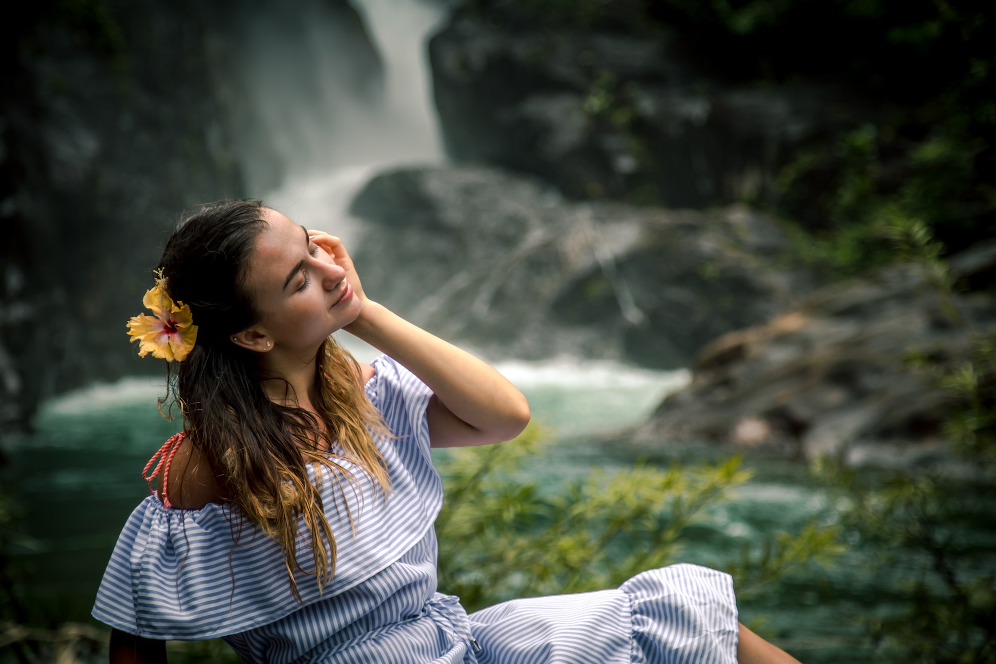 Girl sitting by the waterfall